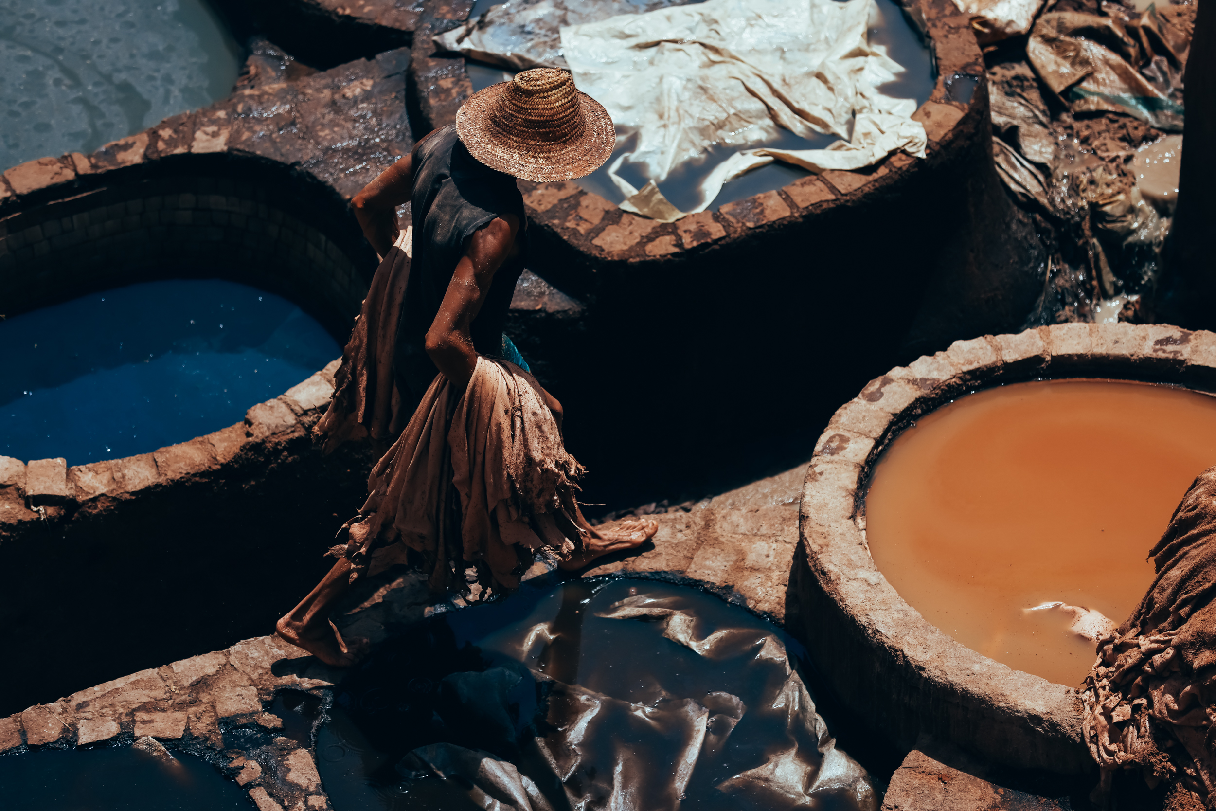 A worker moves between leather dye vats at the traditional tanneries of Fez, Morocco.